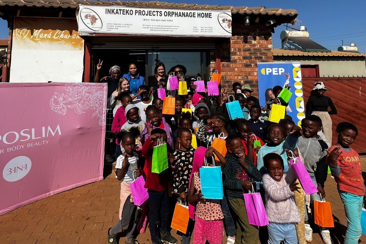 Children at the Inkateko Projects Orphanage Home holding colourful gift bags during a community outreach day